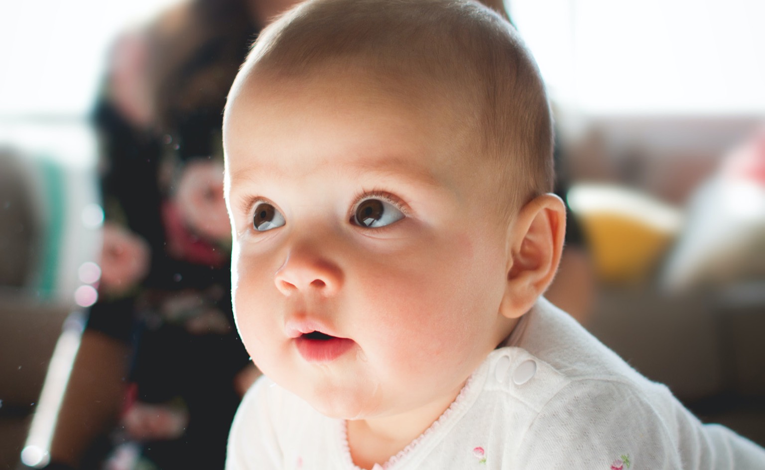 Lachendes Baby blickt zur Seite