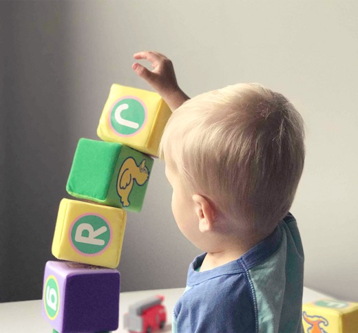 Kind spielt mit bunten Bauklötzen
